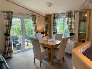 a dining room with a wooden table and chairs at Immaculate 3-Bed Lodge in Otley in Otley