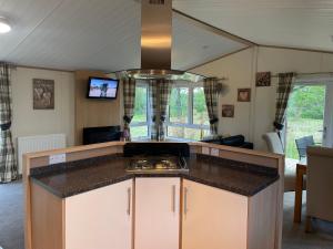 a kitchen with a stove and a counter top at Immaculate 3-Bed Lodge in Otley in Otley