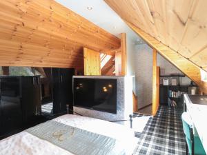 a bedroom with a large tv in a room with wooden ceilings at Swallow Lodge in Morpeth