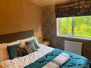 a bedroom with a bed and a window at Immaculate 3-Bed Lodge in Otley in Otley