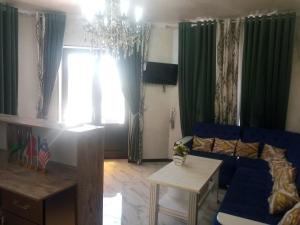 sala de estar con sofá azul y mesa en Hotel Al Hayit Teracce en Bukhara