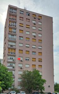 un grand bâtiment rose avec un frisbee rouge dans l'air dans l'établissement Turnic, à Rijeka