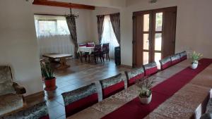 a row of chairs in a room with a table at Pensiunea Romosan in Cucuiş