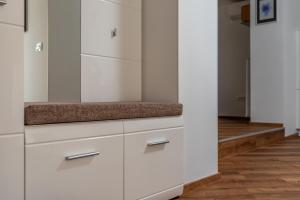 a kitchen with white cabinets and a wooden floor at SEDAMI in Maribor