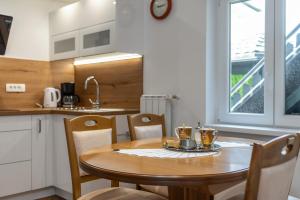 una pequeña cocina con mesa de madera y sillas en SEDAMI en Maribor