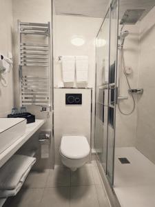 a white bathroom with a toilet and a shower at KYRIAD ROUEN SUD - Sotteville les Rouen in Rouen +59 photos