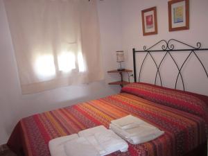 a bedroom with a bed with two towels on it at Apartamento La Torre in El Palmar
