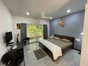 a bedroom with a bed and a desk and a television at The B Hive in Londa