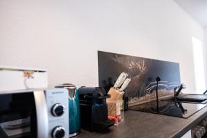 a counter top with a coffee maker and a microwave at Klassen Apartments! Erleben Sie Biberach in diesem Stilvollem Bungalow mit Charme und Komfort in Biberach an der Riß