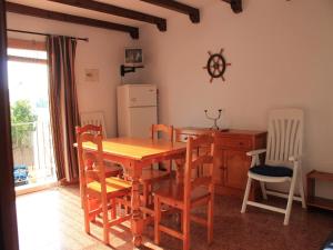 cocina con mesa, sillas y nevera en Apartamento La Torre, en El Palmar