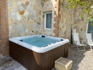 a jacuzzi tub in a patio with a stone wall at Fattoria Maremmana in Marina di Grosseto