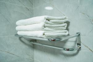 a stack of towels on a towel rack in a bathroom at YAŞAM HOTEL in Izmir
