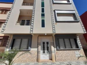 a white house with a door and windows at Appart Clim Wifi 700m de la Plage in Saïdia
