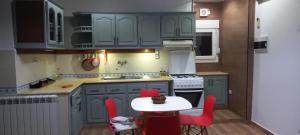 a kitchen with blue cabinets and a table with red chairs at Alger Draria f2 in Alger