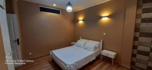 ein kleines Schlafzimmer mit einem weißen Bett und Beleuchtung in der Unterkunft Alger Draria f2 in Alger