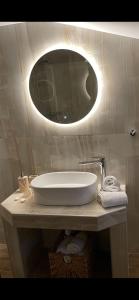 a bathroom with a sink and a mirror on a counter at Barbara's House,New Luxury central apartment in Nea Kalikratia