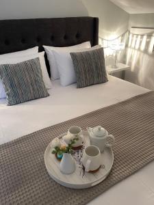 a bed with a tray with tea sets on it at Barbara's House,New Luxury central apartment in Nea Kalikratia