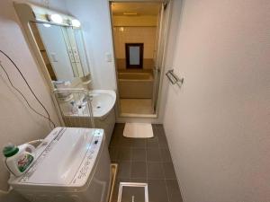 La petite salle de bains est pourvue d'un lavabo et d'une baignoire. dans l'établissement PlusTom Stay-SHIMANOUCHI-, à Osaka