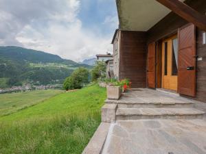 un porche de una casa con vistas a una colina en I Host Apartment - Centrale 18 - Bormio en Piatta