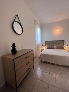 a bedroom with a bed and a mirror on the wall at Appartement rénové tout confort 10mn de Campomoro in Grossa