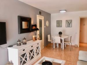 a living room with a table and a living room with a tv at Flamingo in L'Ampolla