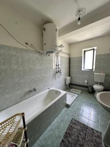 a bathroom with a tub and a toilet and a sink at Hostel Quku i Valbones in Valbonë