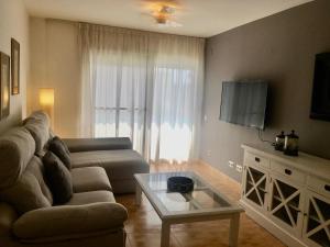 a living room with a couch and a table at Flamingo in L'Ampolla
