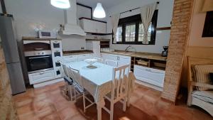 a kitchen with white cabinets and a table with chairs at Finca Las Eras in Herencia
