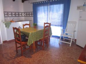 comedor con mesa, sillas y ventana en Apartamento La Torre, en El Palmar