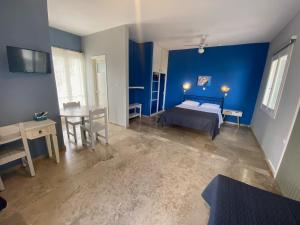 1 dormitorio con paredes azules, 1 cama y 1 mesa en Daphne Bungalows, en Tolo