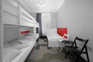 Pokój wieloosobowy z 2 łóżkami piętrowymi i krzesłem w obiekcie Moon Hostel Kraków w Krakowie