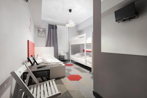 a bedroom with a desk and two bunk beds at Moon Hostel Kraków in Krakow