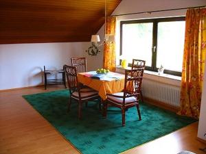 een eetkamer met een tafel en stoelen op een tapijt bij Ferienwohnung "Auszeit" - Familie Moll-Staudt, Langenargen am Bodensee in Langenargen