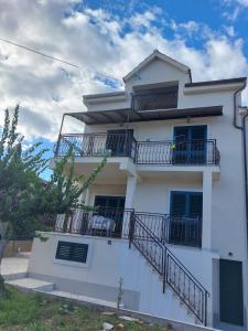 a white house with balconies on the side of it at Apartmani Elisa in Stari Grad