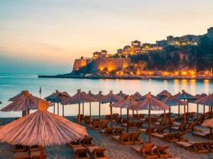 a group of chairs and umbrellas on a beach at Luxury Apartment in Ulcinj