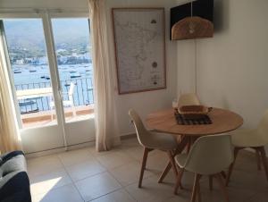 a dining room with a table and chairs and a window at Pianc in Cadaqués