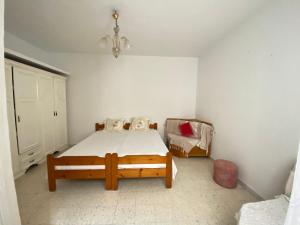 1 dormitorio con 1 cama y 1 silla en Le bien être, en Kelibia