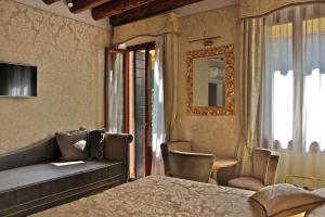 a bedroom with a bed and a couch and a window at B&B Patatina in Venice
