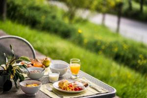 uma mesa com uma bandeja de comida para o pequeno-almoço e sumo de laranja em Gefiri Plakas Hotel by Konnect, Tzoumerka em Plaka