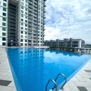 een groot blauw zwembad met twee hoge gebouwen bij Best Modern Design Homestay Meru Casa Kayangan in Ipoh