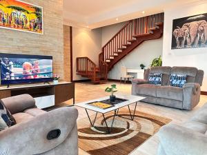 uma sala de estar com dois sofás e uma televisão em Fairview Luxury Apartments em Dar es Salaam