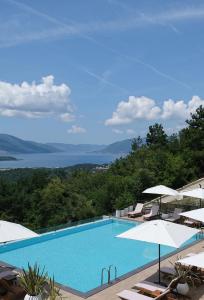 uma piscina com cadeiras e guarda-sóis em Bayview Hills Luxury Residences em Tivat