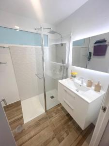a white bathroom with a shower and a sink at 3 bedrooms apartement with wifi at Las Palmas de Gran Canaria in Las Palmas de Gran Canaria