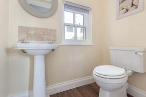 a bathroom with a white toilet and a sink at Cosy 2 bed with parking and garden in Cawston