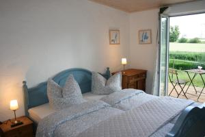 1 dormitorio con cama con almohadas y ventana en Apartment im ART.Quartier, en Velgast