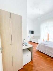 um quarto branco com uma cama e uma secretária em La Canzonetta Affittacamere em Nápoles
