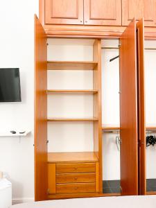um armário com prateleiras de madeira e uma televisão em La Canzonetta Affittacamere em Nápoles