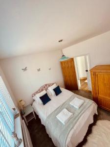 a bedroom with a large white bed with two pillows at Dot's Escape - 2 bed bungalow. in Kent