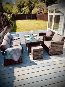 un patio avec des canapés et une table sur une terrasse dans l'établissement Dot's Escape - 2 bed bungalow., à Kent
