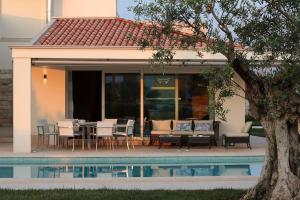 a patio with a table and chairs next to a pool at Luxury villa Lara with private pool in Banjole